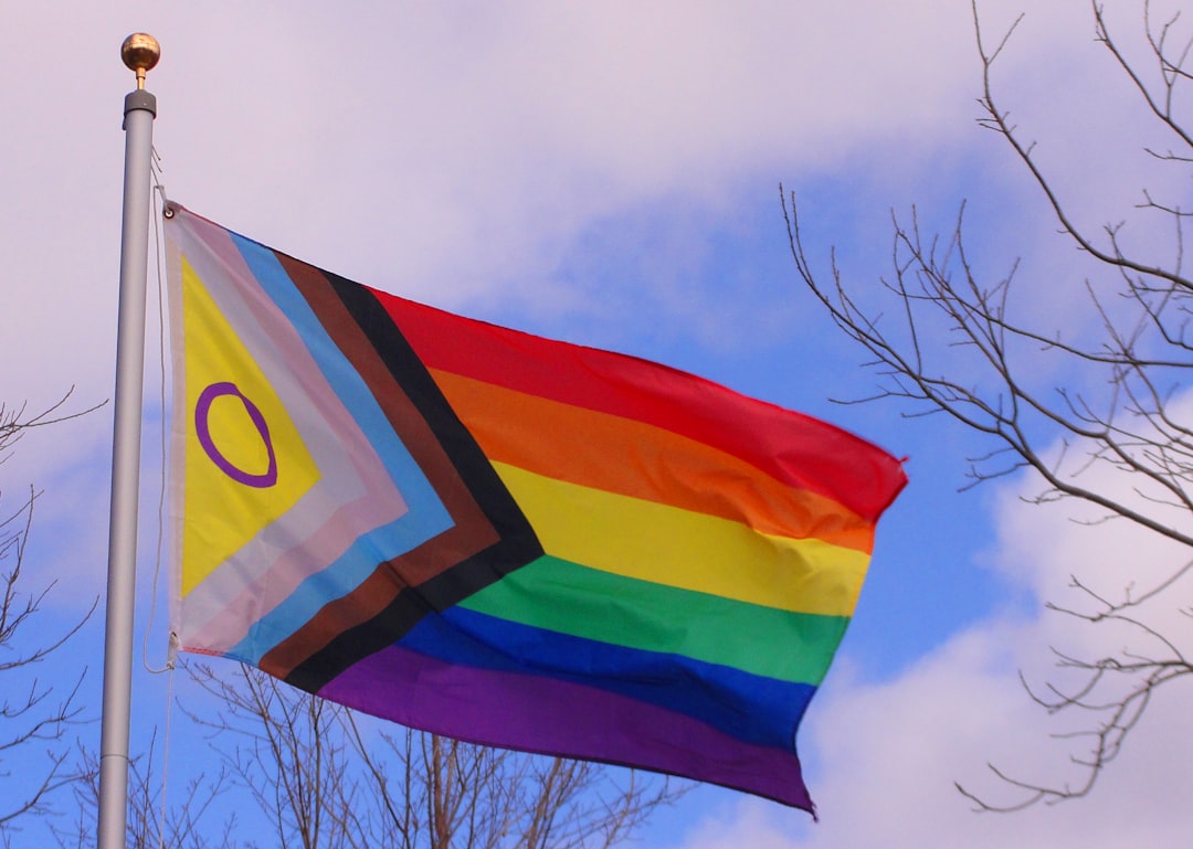 A progress pride flag is waving in the breeze. A progress pride flag is waving in the breeze.