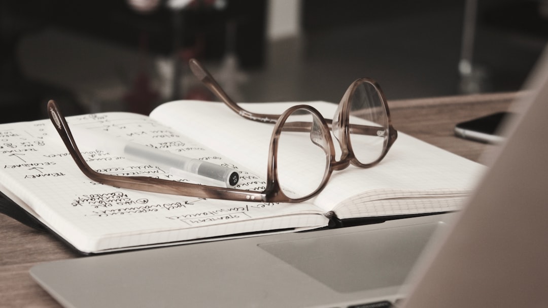 eyeglasses with gray frames on the top of notebook eyeglasses with gray frames on the top of notebook