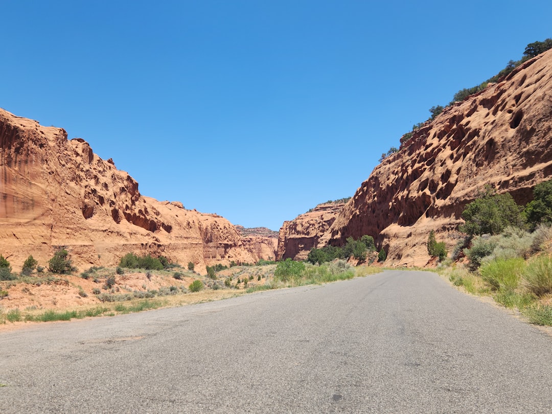 A road in the middle of a desert with a mountain in the background A road in the middle of a desert with a mountain in the background