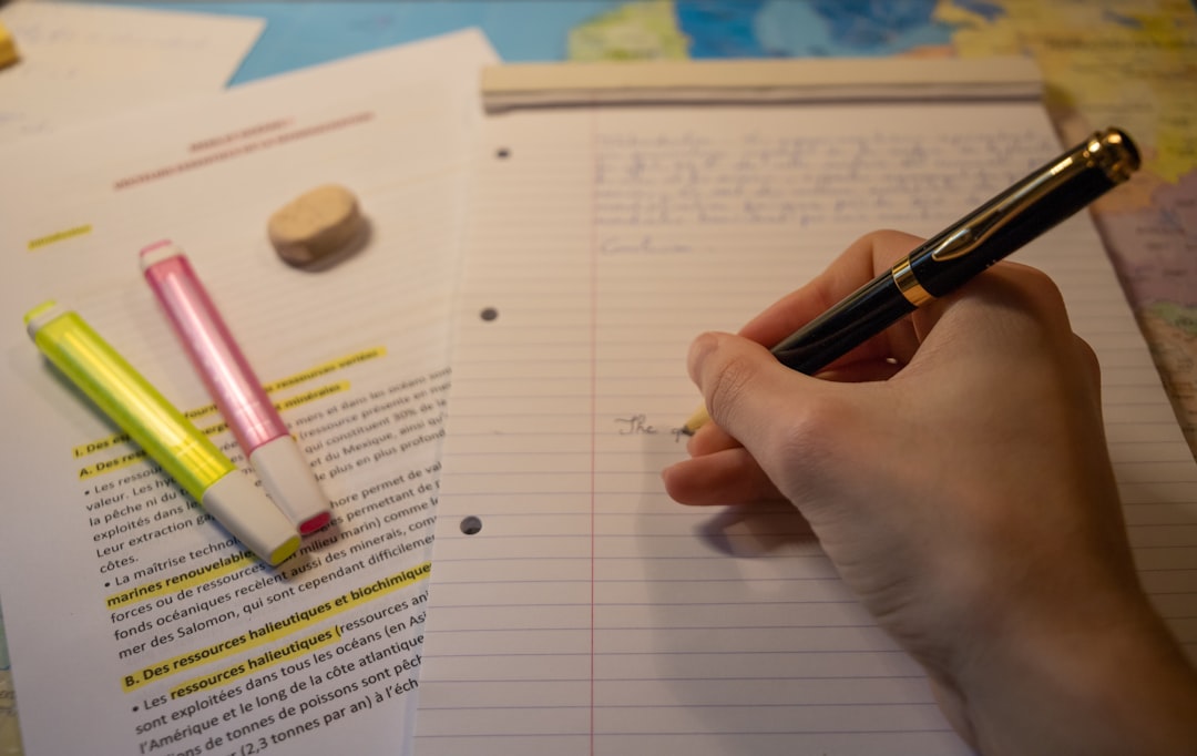 a person writing on a notebook with a pen a person writing on a notebook with a pen