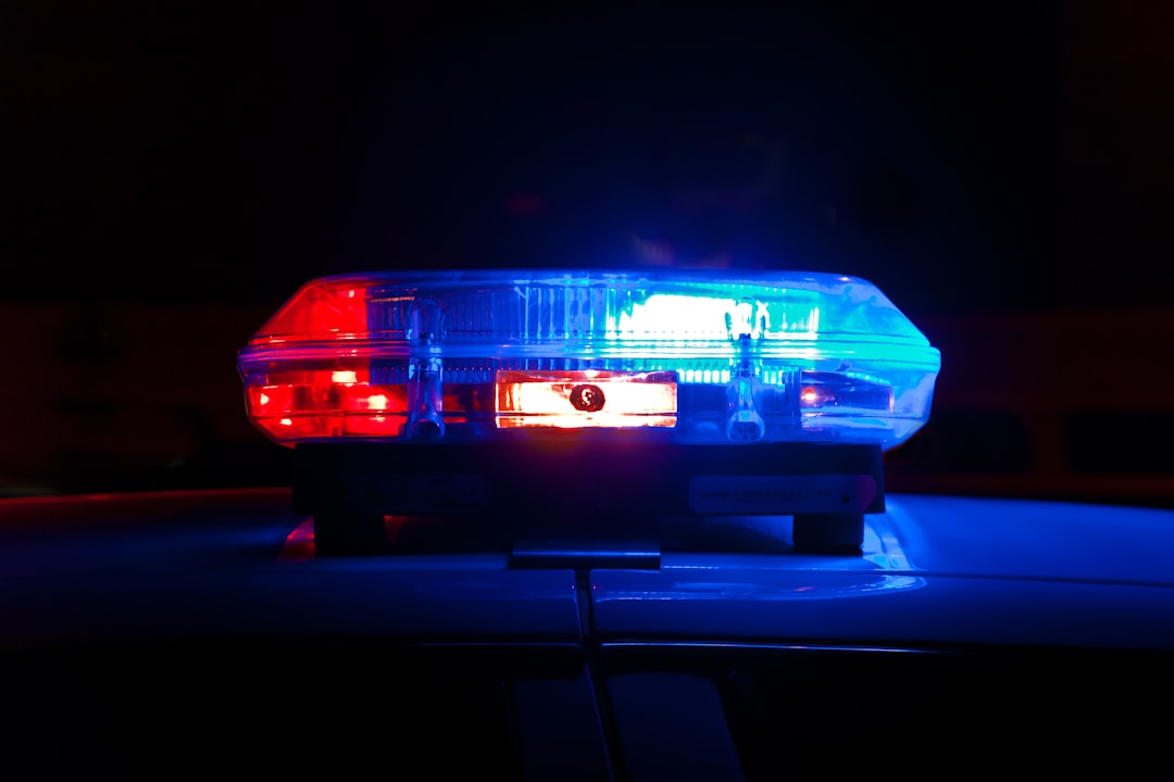 A police light bar flashing red and blue against a dark night background A police light bar flashing red and blue against a dark night background